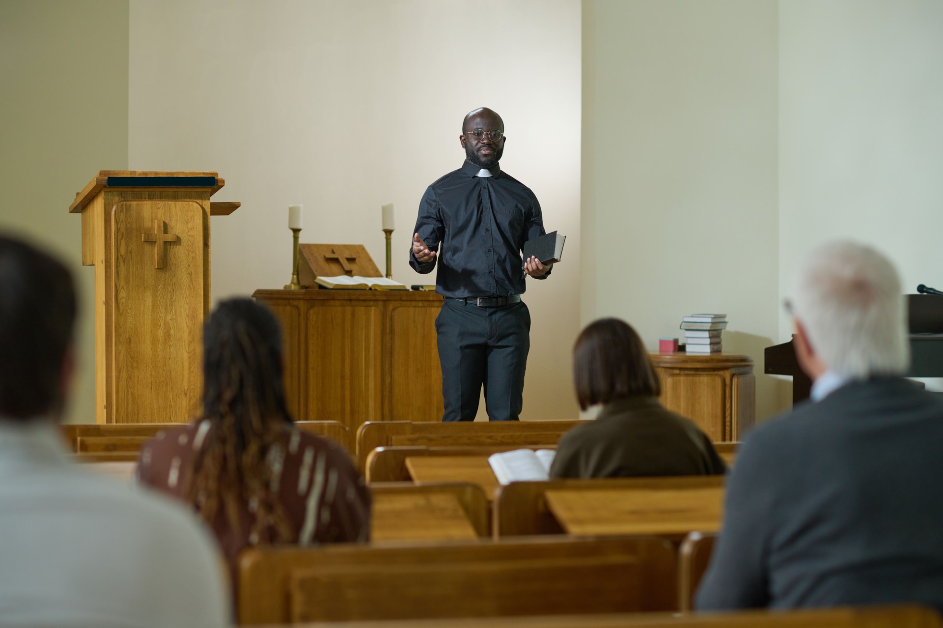 Confident priest of evangelical church with Bible in hand saying sermon